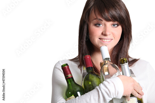 Photo: young woman holding empty wine bottles young woman holding empty wine bottles
