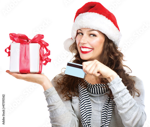 Photo: Christmas. Happy Smiling Woman with Gift Box and Credit Card Christmas. Happy Smiling Woman with Gift Box and Credit Card