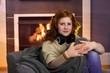 Teenage girl sitting at home at fireplace
