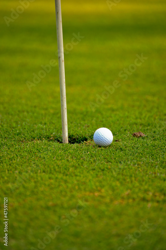Photo: golf ball on lip of cup golf ball on lip of cup