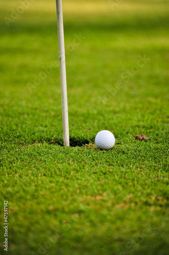 Photo: golf ball on lip of cup golf ball on lip of cup
