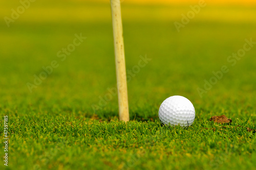 Photo: golf ball on lip of cup golf ball on lip of cup