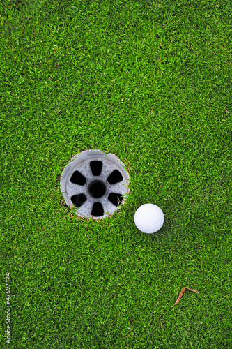 Photo: golf ball on lip of cup golf ball on lip of cup