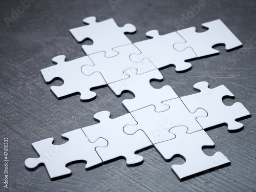 Photo: Unfinished white jigsaw on stone floor Unfinished white jigsaw on stone floor