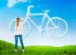 Photo: Beautiful nature background with a girl drawing bicycle Beautiful nature background with a girl drawing bicycle