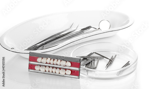 Photo: denture with dental tools isolated on white denture with dental tools isolated on white