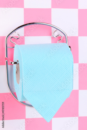 Photo: Roll of toilet paper on holder fixed to wall in bathroom Roll of toilet paper on holder fixed to wall in bathroom