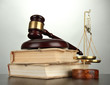 Golden scales of justice, gavel and books on grey background
