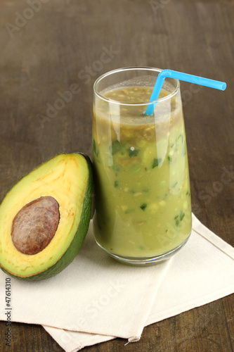 Photo: Useful fresh avocado and half avocado on wooden table close-up Useful fresh avocado and half avocado on wooden table close-up