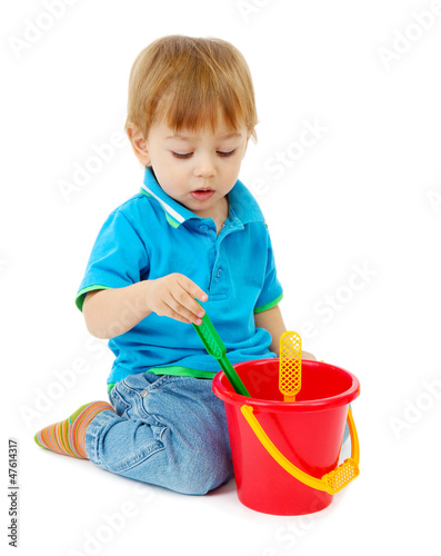 Photo: cute little boy with toy bucket, isolated on white cute little boy with toy bucket, isolated on white