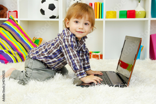 Photo: cute little boy and notebook in room cute little boy and notebook in room