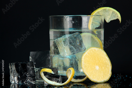Photo: Ice cubes in glass with lemon on dark blue background Ice cubes in glass with lemon on dark blue background