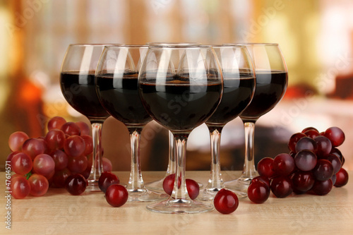 Photo: Red wine in glass on room background Red wine in glass on room background