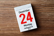 Kalender vor Holzhintergrund - Heiligabend 24.12.