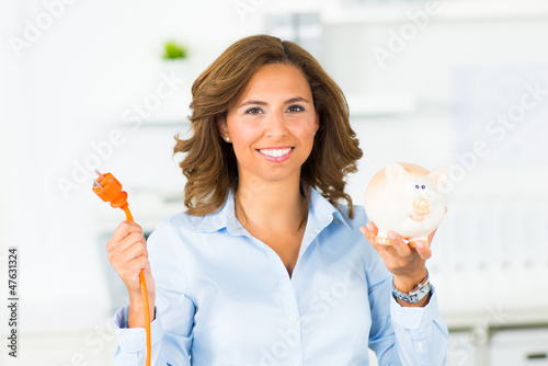 Photo: frau mit stromkabel und sparschwein frau mit stromkabel und sparschwein