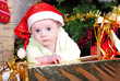 Small breast child near new year's fir tree with gift
