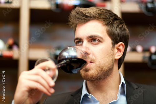 Photo: Man tasting a glass of red wine Man tasting a glass of red wine