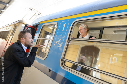 Photo: Man blowing kiss to woman on train Man blowing kiss to woman on train