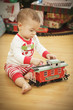 Infant Baby Enjoying Christmas Morning Near The Tree