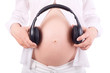 Photo: Hands of pregnant woman holding headphones close to belly Hands of pregnant woman holding headphones close to belly
