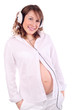 Pregnant woman in white listens to music on white headphones