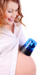 Pregnant woman in white puts blue flasher on belly isolated