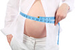 Belly of pregnant woman in white measuring belly