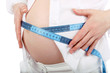 Belly of pregnant woman measuring belly by centimeter tape