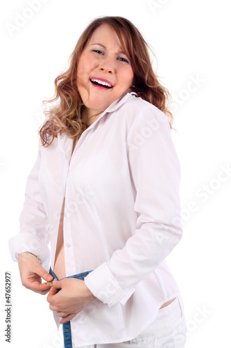 Photo: Pregnant woman in white tries to tighten centimeter tape Pregnant woman in white tries to tighten centimeter tape