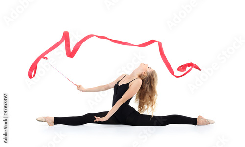 Photo: Beautiful ballerina in black suit sits on twine with red ribbon Beautiful ballerina in black suit sits on twine with red ribbon