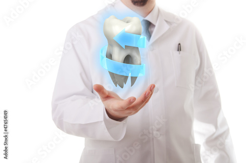 Photo: Male dentist showing a molar tooth Male dentist showing a molar tooth