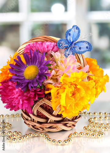 Photo: Beautiful bouquet of bright flowers in small basket with paper Beautiful bouquet of bright flowers in small basket with paper