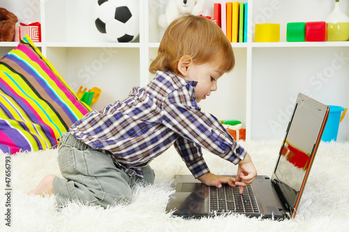 Photo: cute little boy and notebook in room cute little boy and notebook in room