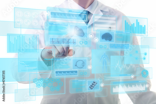 Photo: Male doctor working on a futuristic touchscreen display Male doctor working on a futuristic touchscreen display