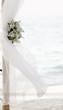 Photo: fresh white flowers as wedding decoration on beach isolated over fresh white flowers as wedding decoration on beach isolated over