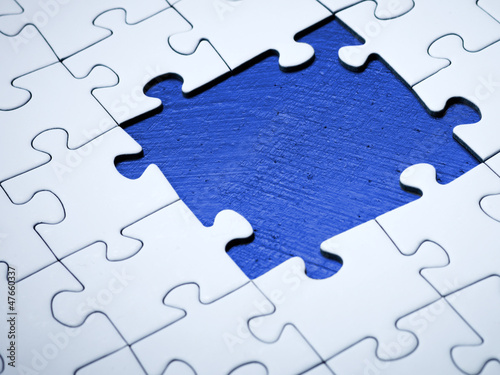 Photo: White jigsaw with missing pieces White jigsaw with missing pieces