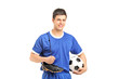 Smiling footballer in sport wear holding a soccer shoes and foot