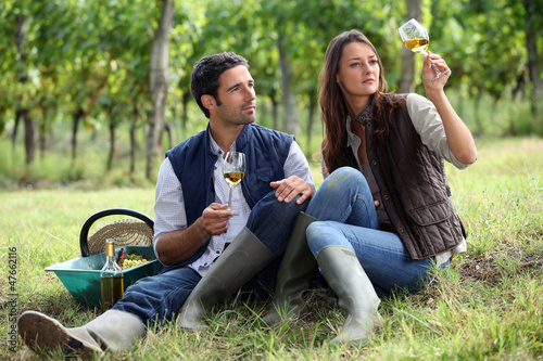 Photo: Couple of winegrowers with glasses of wine Couple of winegrowers with glasses of wine