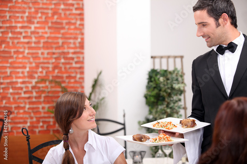 Photo: women at restaurant with waiter women at restaurant with waiter