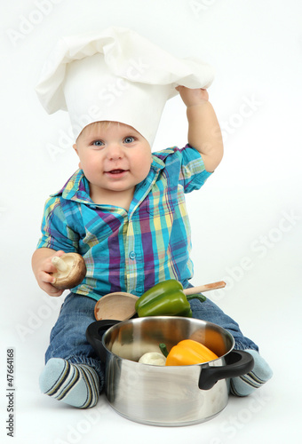 Photo: Little boy in chef's hat with pan and vegetables, isolated Little boy in chef's hat with pan and vegetables, isolated