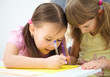 Little girl is writing using a pen