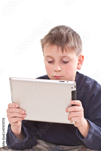 Photo: Teen plays on the tablet computer Teen plays on the tablet computer