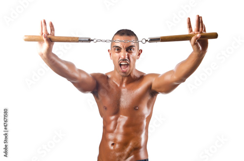 Photo: Man in martial arts concept with nunchucks Man in martial arts concept with nunchucks
