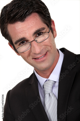 Photo: Portrait of a businessman peering over his glasses Portrait of a businessman peering over his glasses