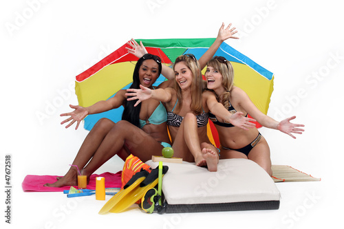 Photo: Young women at the beach, studio shot Young women at the beach, studio shot
