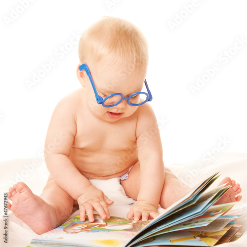 Photo: Baby in glasses reading a book and learning Baby in glasses reading a book and learning