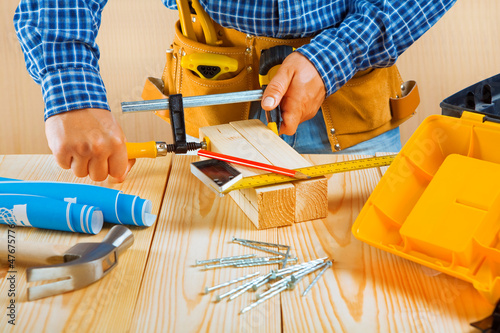 Photo: worker fixes two wooden planks worker fixes two wooden planks