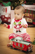 Infant Mixed Race Baby Enjoying Christmas Morning Near The Tree