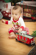 Infant Mixed Race Baby Enjoying Christmas Morning Near The Tree