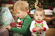 Mixed Race Baby and Young Boy Enjoying Christmas Morning Near Th